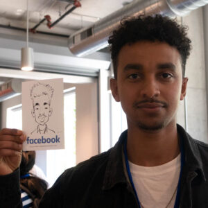 Guest at a Facebook company event holding their caricature print